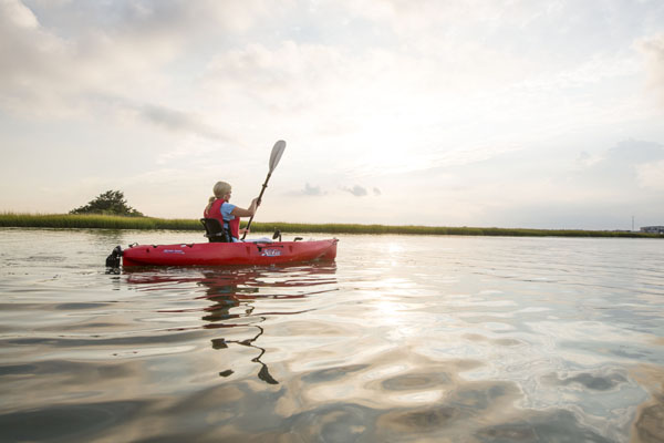A women kayaks in the Wildwoods at dawn.